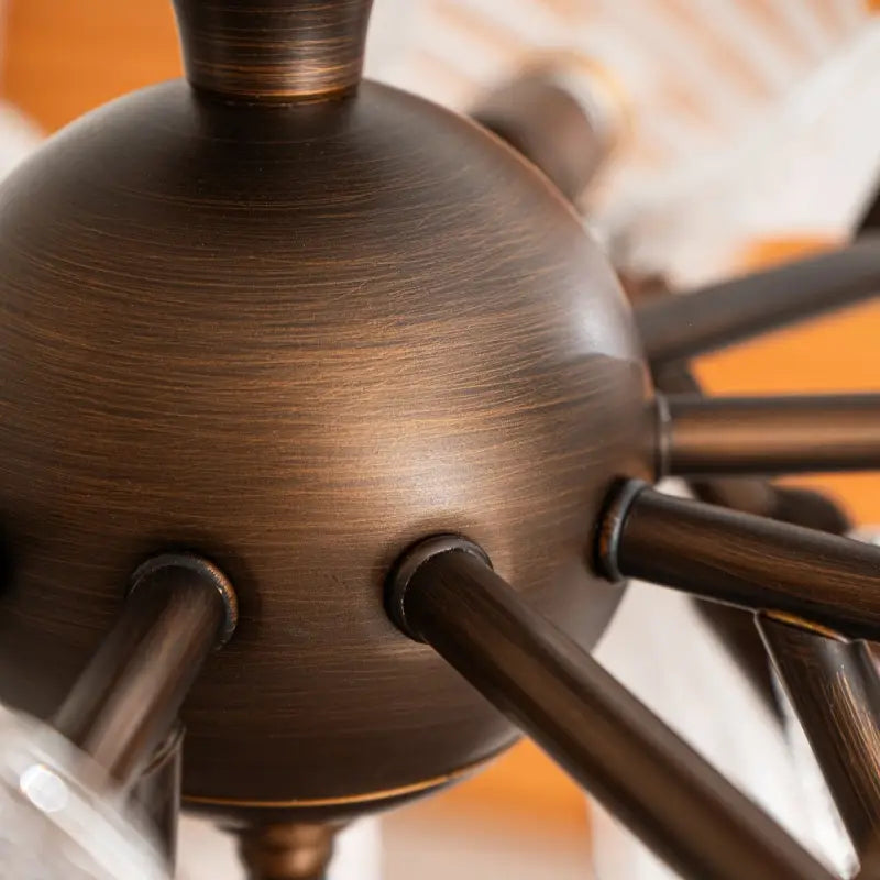 Close-up antique bronze metal sphere and arm structure of vintage butterfly glass semi flush ceiling light, brushed dark bronze texture