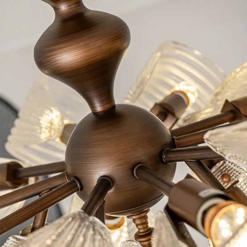 Detail shot of antique bronze central body and radial arms for vintage butterfly glass semi flush ceiling light, wrought metal lamp structure