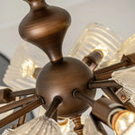 Detail shot of antique bronze central body and radial arms for vintage butterfly glass semi flush ceiling light, wrought metal lamp structure