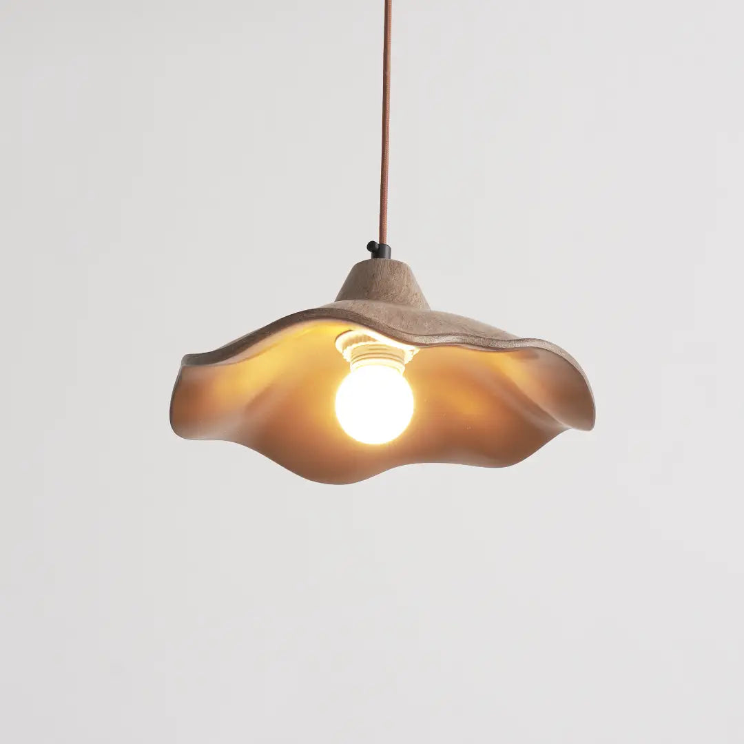 Glowing gently indoors, wavy cement pendant light delivers balanced lighting for home interior