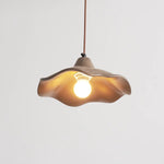 Glowing gently indoors, wavy cement pendant light delivers balanced lighting for home interior