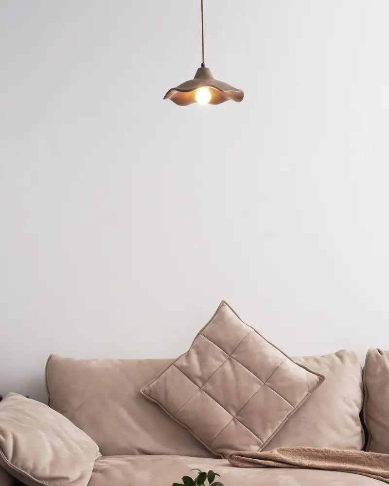 Soft ambient light radiates from wavy cement pendant light and warms up the whole living room space