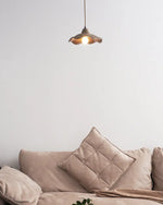 Soft ambient light radiates from wavy cement pendant light and warms up the whole living room space