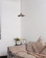 wavy cement pendant light with undulating outline adorns living room ceiling in unlit state