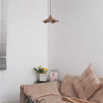 Wavy Cement Pendant Light hanging above a cozy sofa in a modern living room setting.