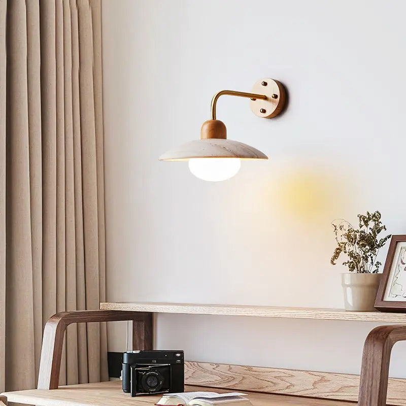 Zanara Travertine Wall Lamp illuminating a cozy workspace with wooden accents and soft lighting.